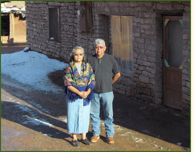 A Pueblo couple standing in front of their home.